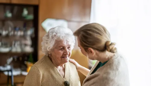 Tochter im Gespräch mit ihrer alten Mutter