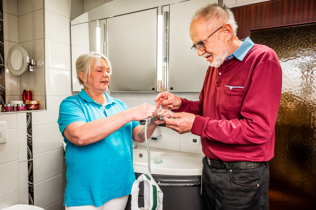 HomeCare-Anbieter Mitarbeiter erklärt ein Pflegehilfsmittel