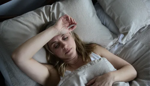 Schlaflose Frau, die sich im Bett frustriert fühlt.